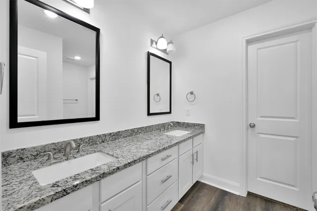 a bathroom with double vanity sink and a mirror