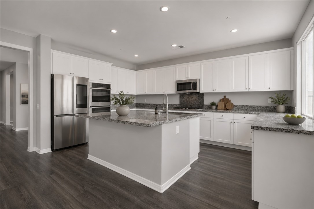 11056 Guffey Ranch Way Corona, CA 92883 - Photo 12 of 61 a kitchen with stainless steel appliances granite countertop a refrigerator a stove top oven a sink and dishwasher with wooden floor