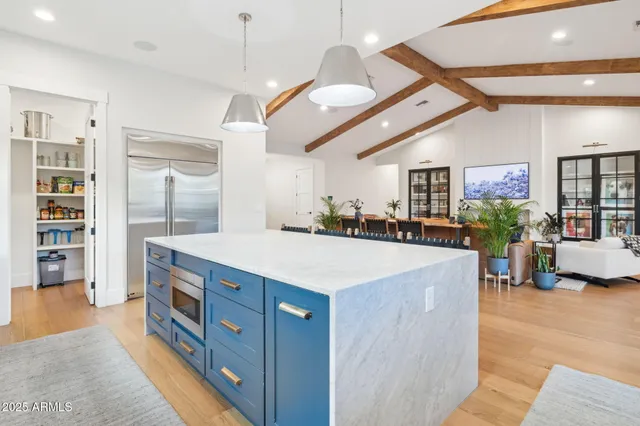 a large kitchen with kitchen island a large island in it