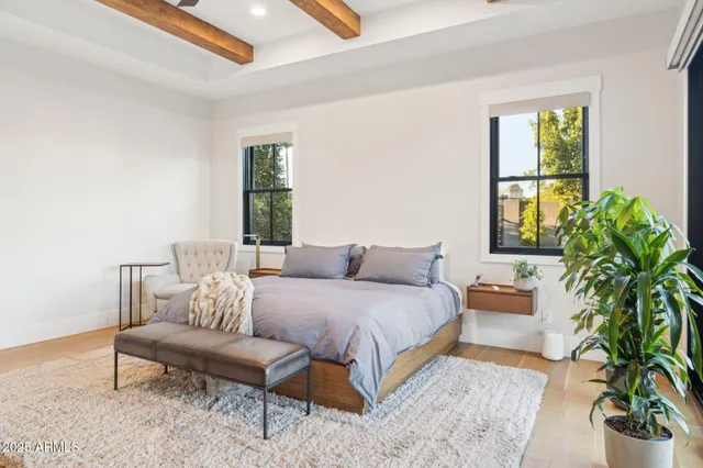 a spacious bedroom with a bed a couch and a large window