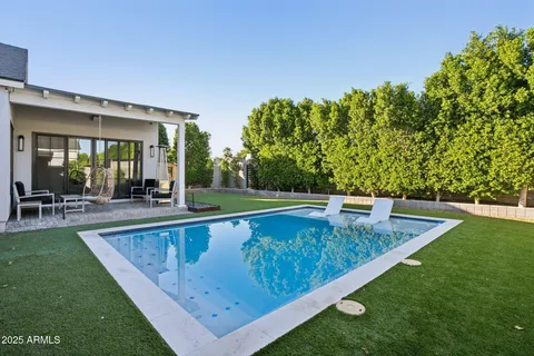 a view of a house with swimming pool and sitting area