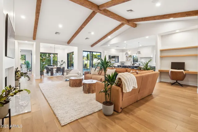 a living room with fireplace furniture and a large window