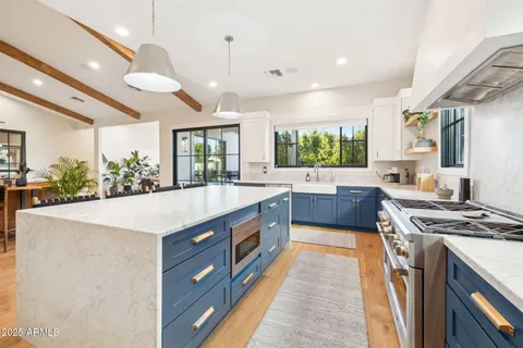 a large kitchen with stainless steel appliances granite countertop a stove a sink and a refrigerator