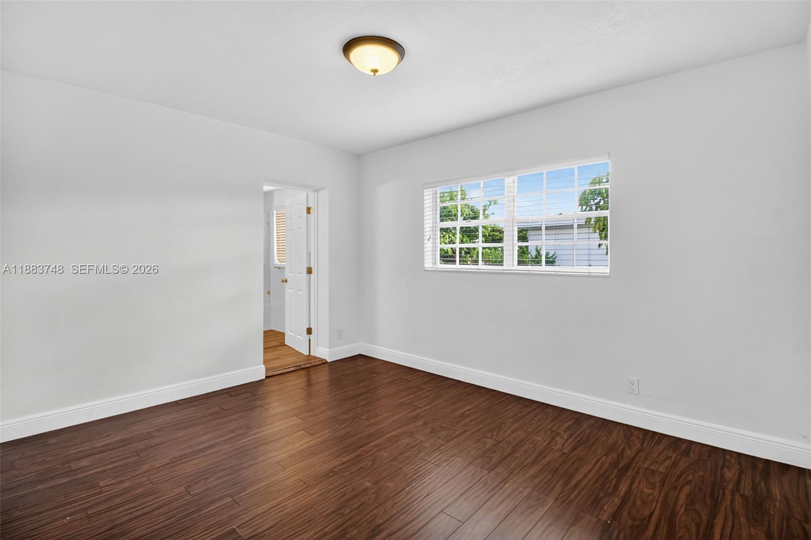 8371 Southwest 32nd Terrace Miami, FL 33155 - Photo 21 of 48 an empty room with wooden floor and windows