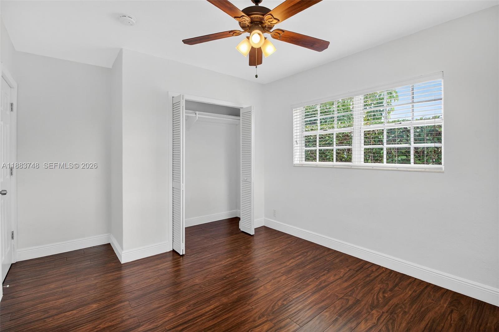8371 Southwest 32nd Terrace Miami, FL 33155 - Photo 29 of 48 an empty room with wooden floor chandelier fan and windows