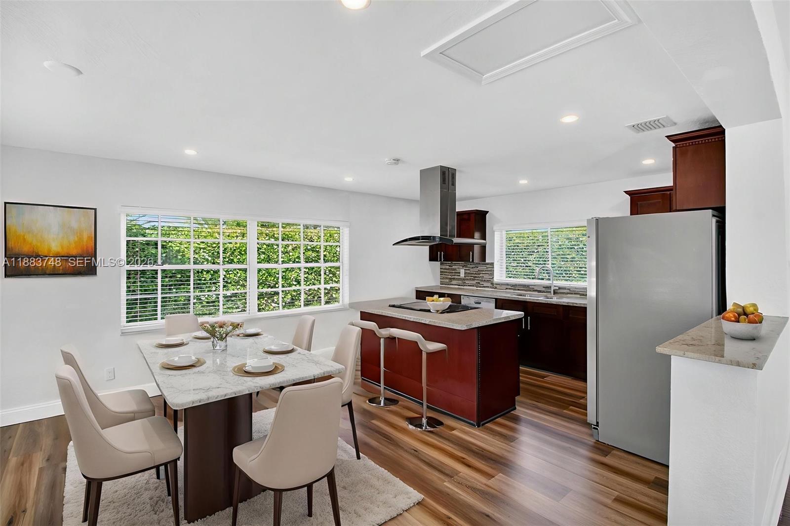 8371 Southwest 32nd Terrace Miami, FL 33155 - Photo 9 of 48 a kitchen with stainless steel appliances granite countertop a stove a refrigerator a sink a dining table and chairs with wooden floor