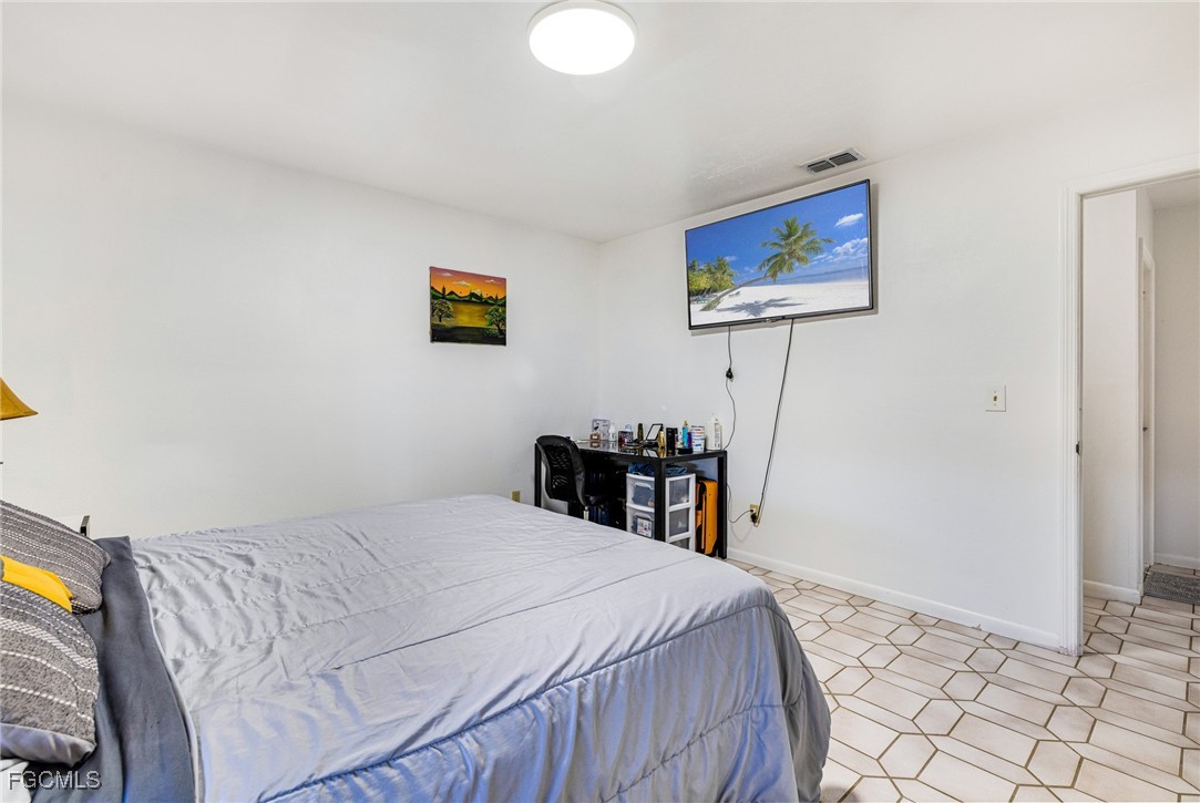 1472 Charolais Road Northwest LaBelle, FL 33935 - Photo 28 of 50 a bedroom with a bed and a bookshelf