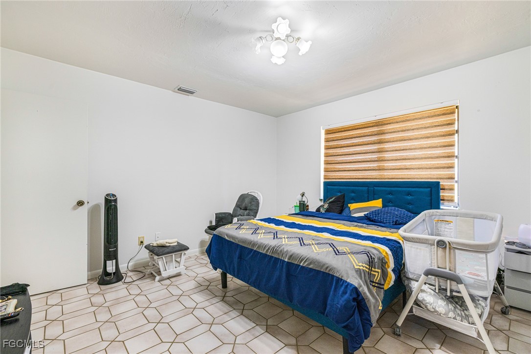 1472 Charolais Road Northwest LaBelle, FL 33935 - Photo 32 of 50 a bedroom with a bed and a table in it