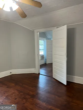 an empty room with wooden floor & bathroom