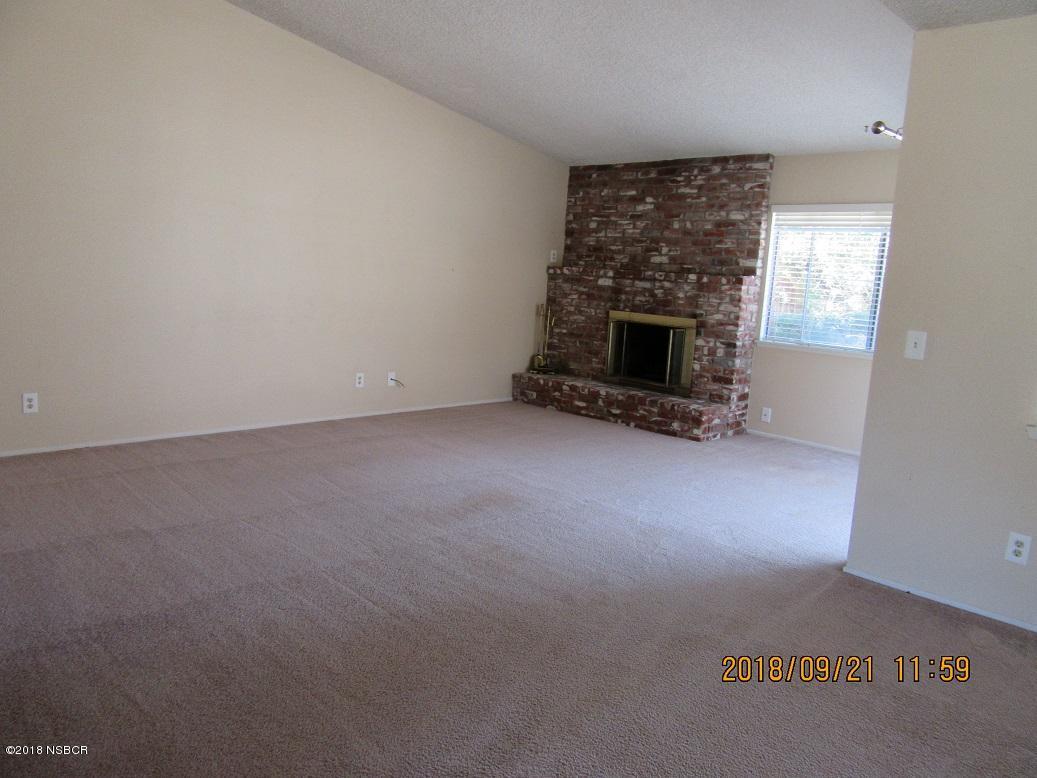 4376 Rigel Avenue Lompoc, CA 93436 - Photo 8 of 20 an empty room with a fireplace and windows