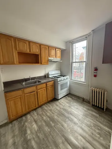 a kitchen with granite countertop a sink cabinets and window