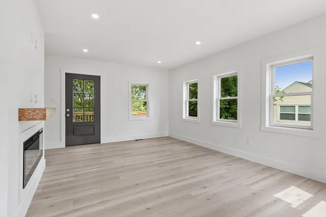 a view of an empty room with a window and fire place