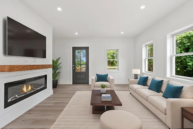 a living room with furniture a flat screen tv and a fireplace