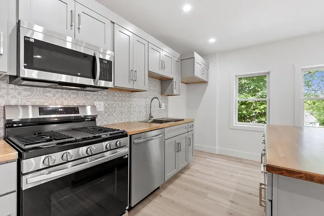a kitchen with stainless steel appliances a stove a microwave and cabinets