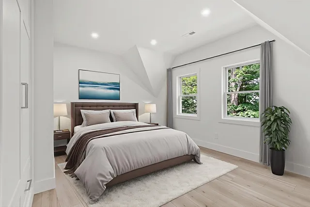a bedroom with a large bed and a potted plant