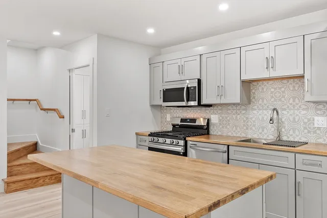 a kitchen with granite countertop white cabinets and appliances