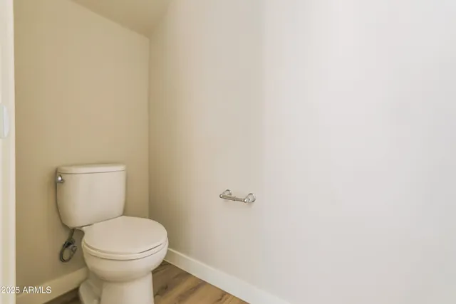 a white toilet sitting next to a white wall