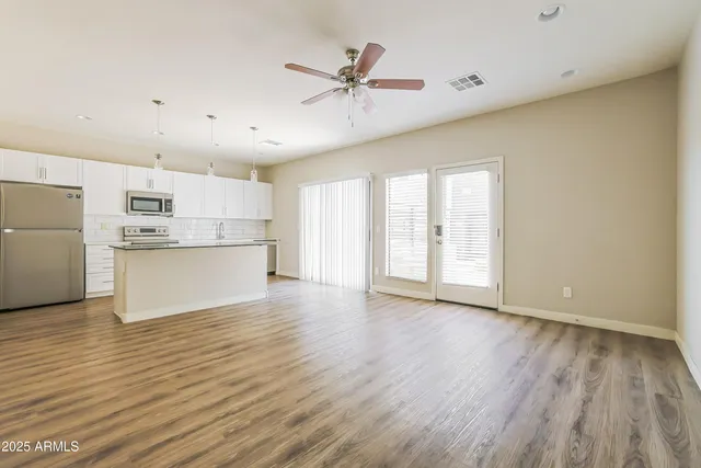 a view of a kitchen with wooden floor and a ceiling fan