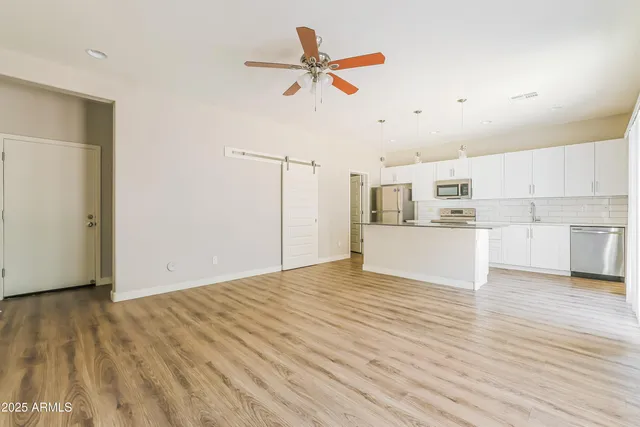 a view of a kitchen with wooden floor and a ceiling fan
