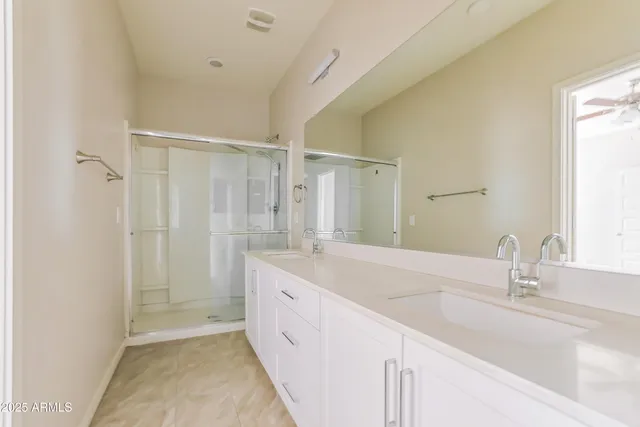 a bathroom with a double vanity sink mirror and shower