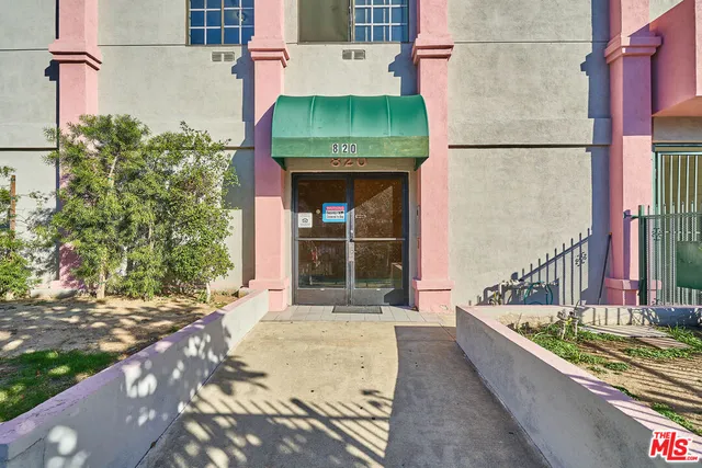 a view of a house with a small yard and potted plants