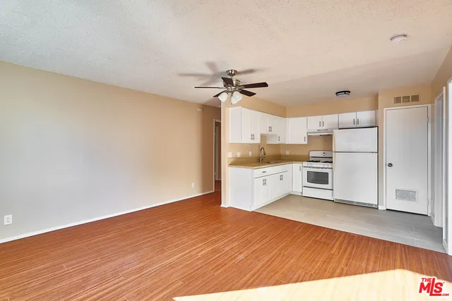 a kitchen with stainless steel appliances white cabinets and wooden floors