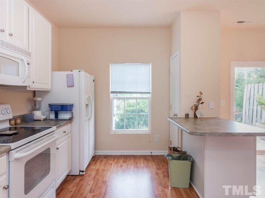 8149 Rhiannon Road Raleigh, NC 27613 - Photo 11 of 25 a kitchen with stainless steel appliances granite countertop a stove a sink and a refrigerator
