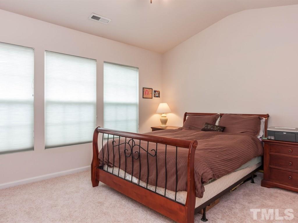 8149 Rhiannon Road Raleigh, NC 27613 - Photo 13 of 25 a bed sitting in a bedroom next to a window