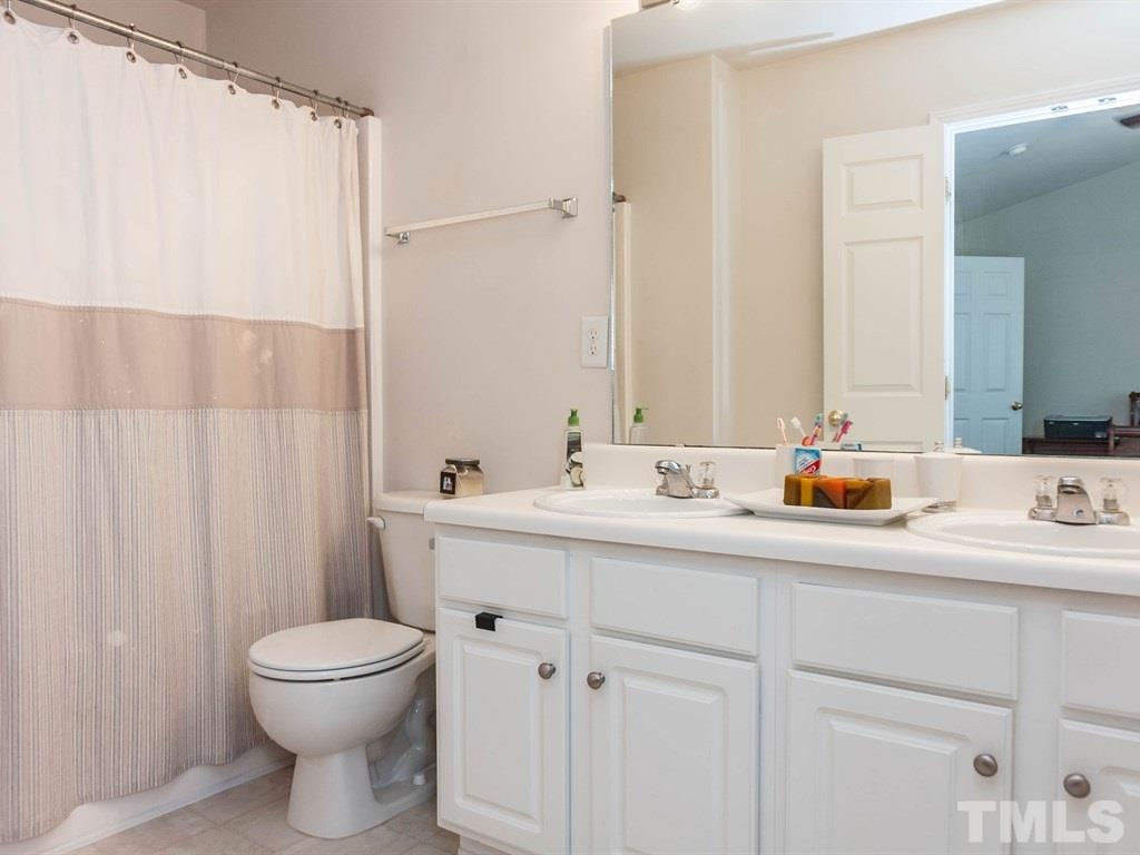 8149 Rhiannon Road Raleigh, NC 27613 - Photo 15 of 25 a bathroom with a sink a toilet and mirror