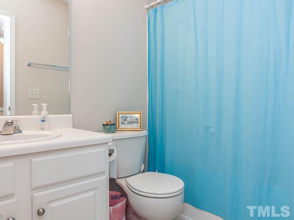 8149 Rhiannon Road Raleigh, NC 27613 - Photo 17 of 25 a bathroom with a sink a toilet and a mirror