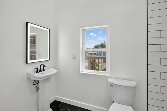 a bathroom with a sink mirror and a toilet