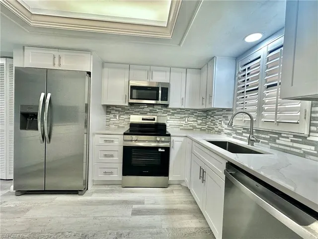 a kitchen with stainless steel appliances a refrigerator sink and microwave