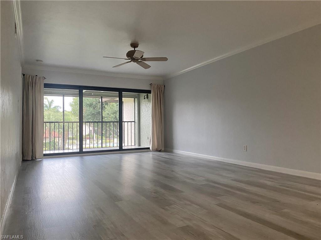 4955 Pepper Circle, Unit B204 Naples, FL 34113 - Photo 22 of 25 a view of an empty room with a window and wooden floor