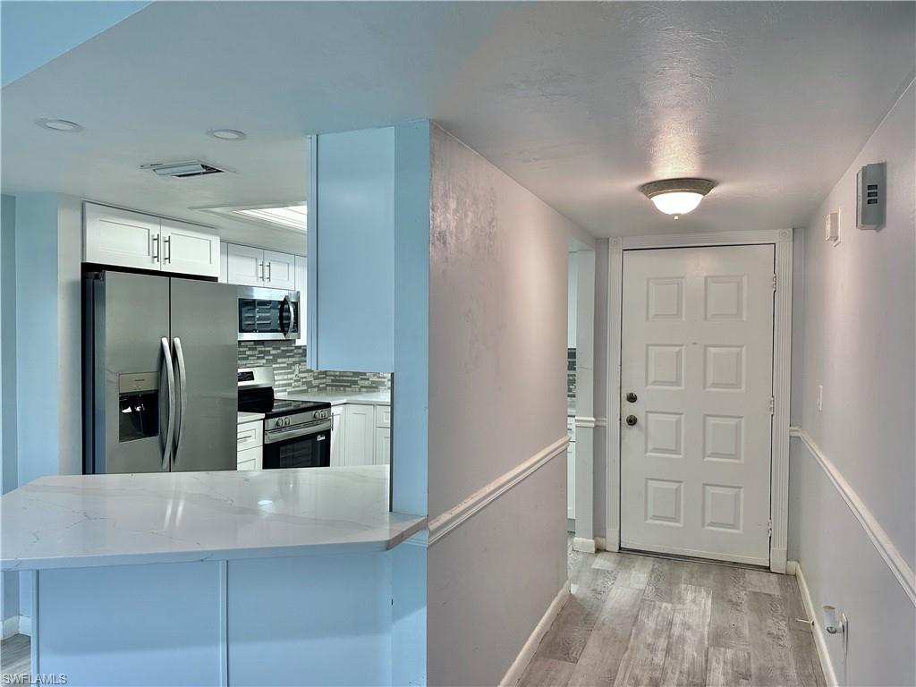 4955 Pepper Circle, Unit B204 Naples, FL 34113 - Photo 24 of 25 a kitchen with stainless steel appliances a refrigerator and a stove