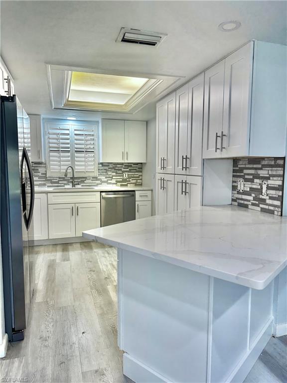 4955 Pepper Circle, Unit B204 Naples, FL 34113 - Photo 4 of 25 a kitchen with kitchen island granite countertop a stove refrigerator and cabinets