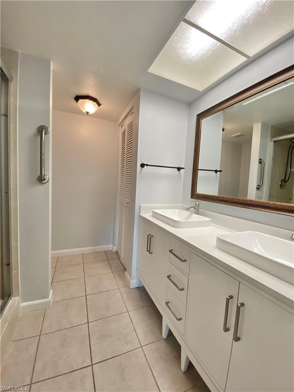 4955 Pepper Circle, Unit B204 Naples, FL 34113 - Photo 9 of 25 a bathroom with a double vanity sink and mirror