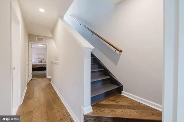 a view of a hallway with wooden floor and staircase