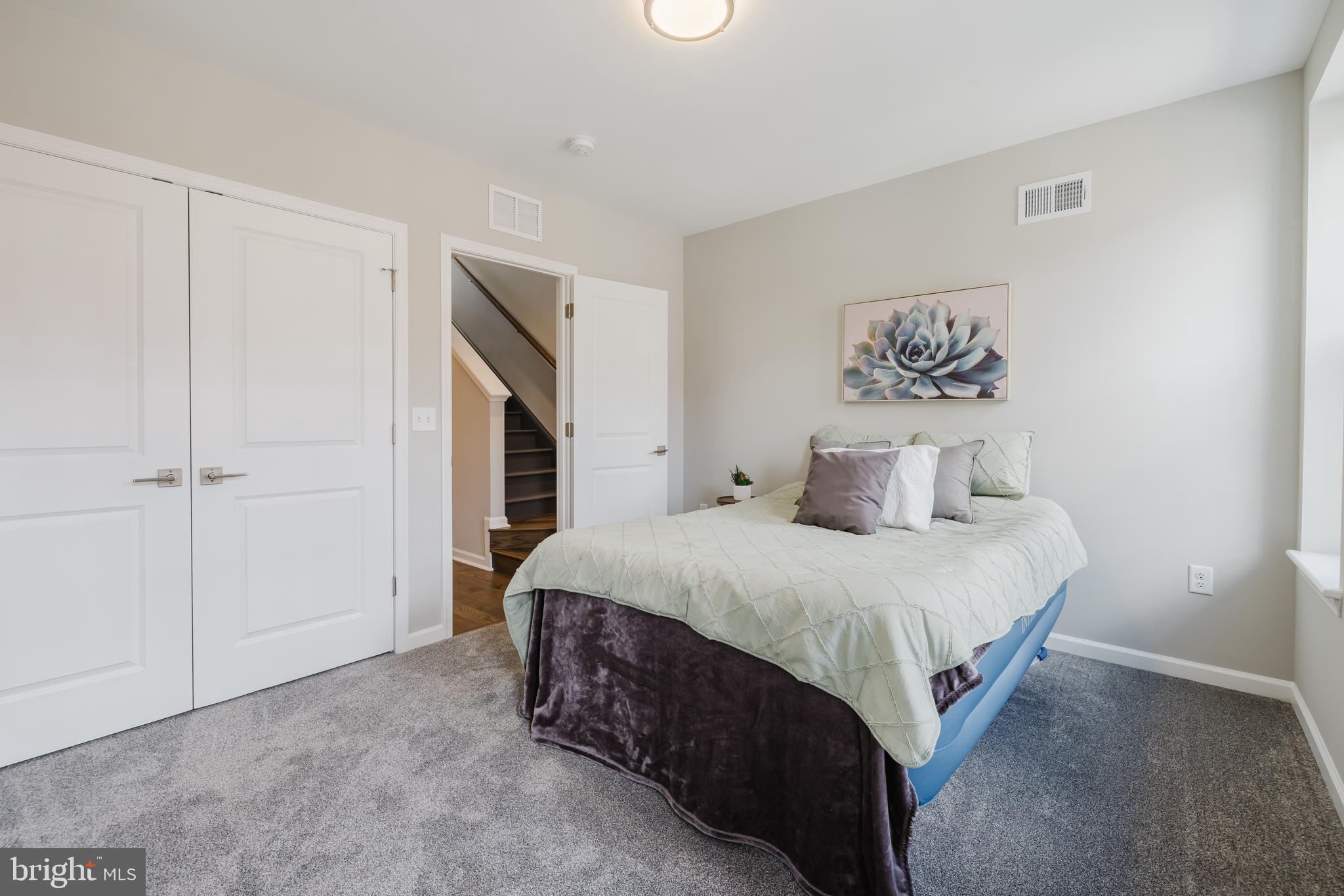 711 East Preston Street Baltimore, MD 21202 - Photo 19 of 27 a spacious bedroom with a bed and a painting on the wall