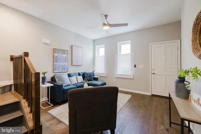 a living room with furniture potted plant and wooden floor