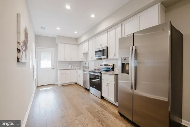 a kitchen with a refrigerator a sink and a stove top oven