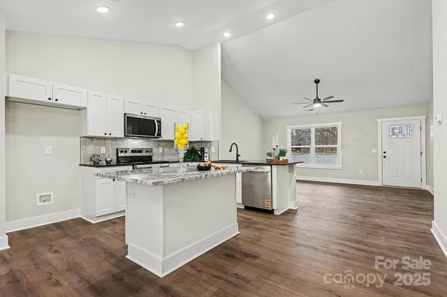 a kitchen with white cabinets and appliances