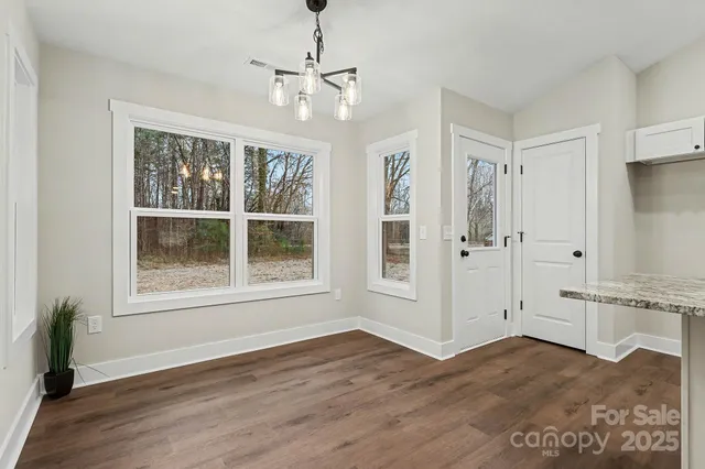 a view of empty room with wooden floor and window