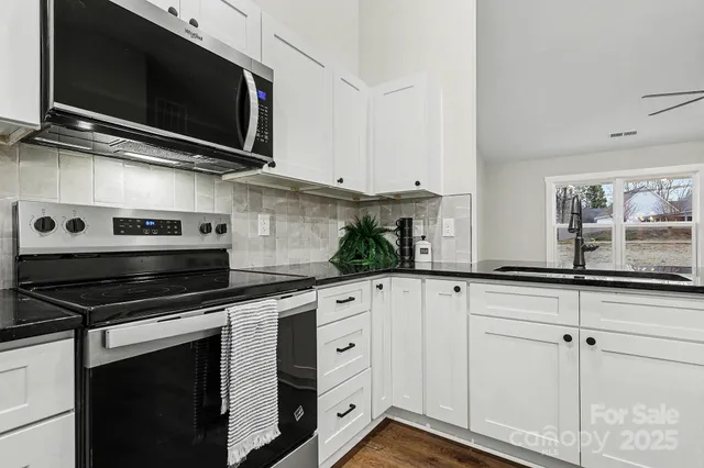 a kitchen with stainless steel appliances white cabinets and a stove a oven