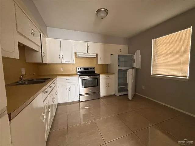 a kitchen with a stove a sink and a microwave