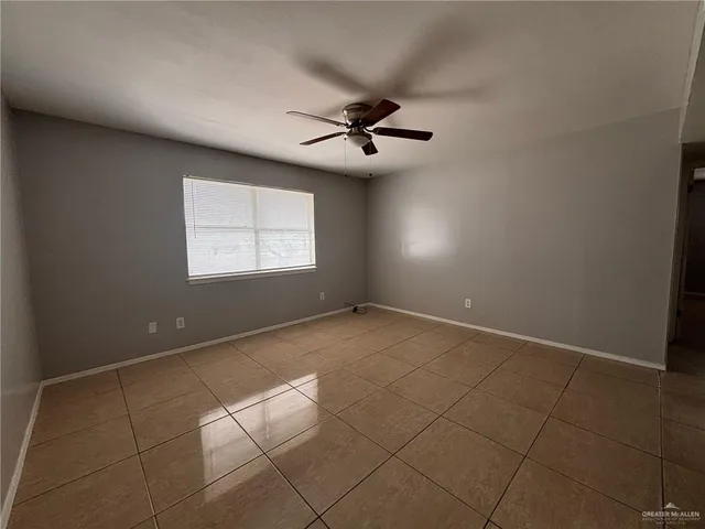 an empty room with windows and fan