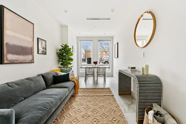 a living room with furniture a large window and a chandelier
