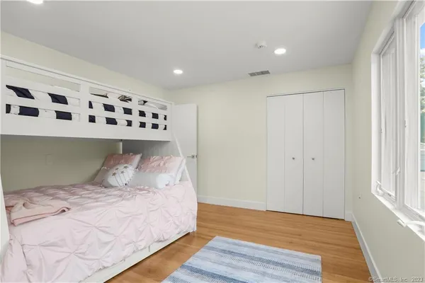 a bedroom with a large bed and wooden floor