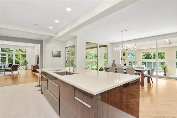 a large kitchen with kitchen island a large window in it