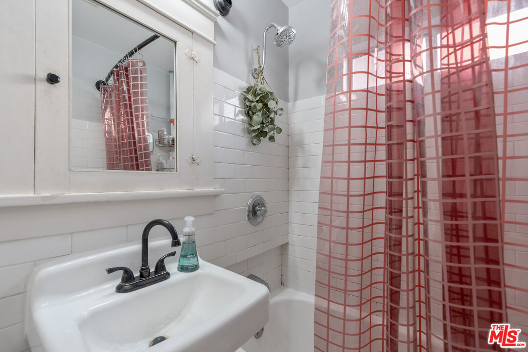 1767 Locust Street Pasadena, CA 91106 - Photo 13 of 28 a bathroom with a sink a mirror and shower