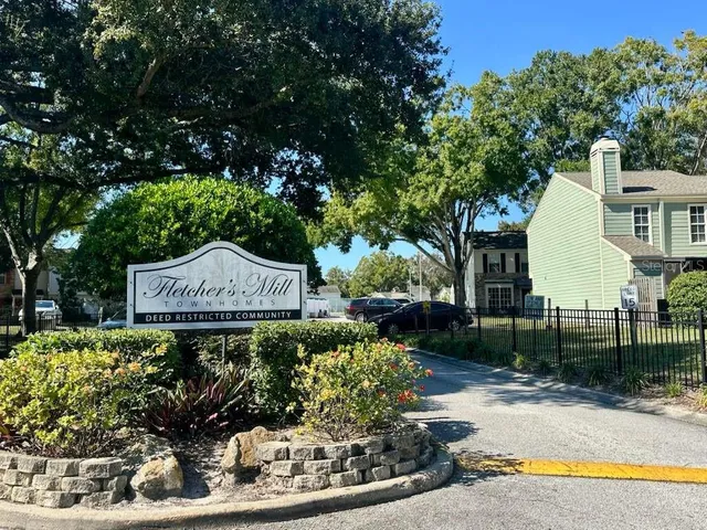 a view of a house with a small yard and wooden fence
